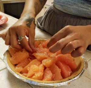 Artist, Celeste De Luna begins arranging the layers of ruby red grapefruit slices